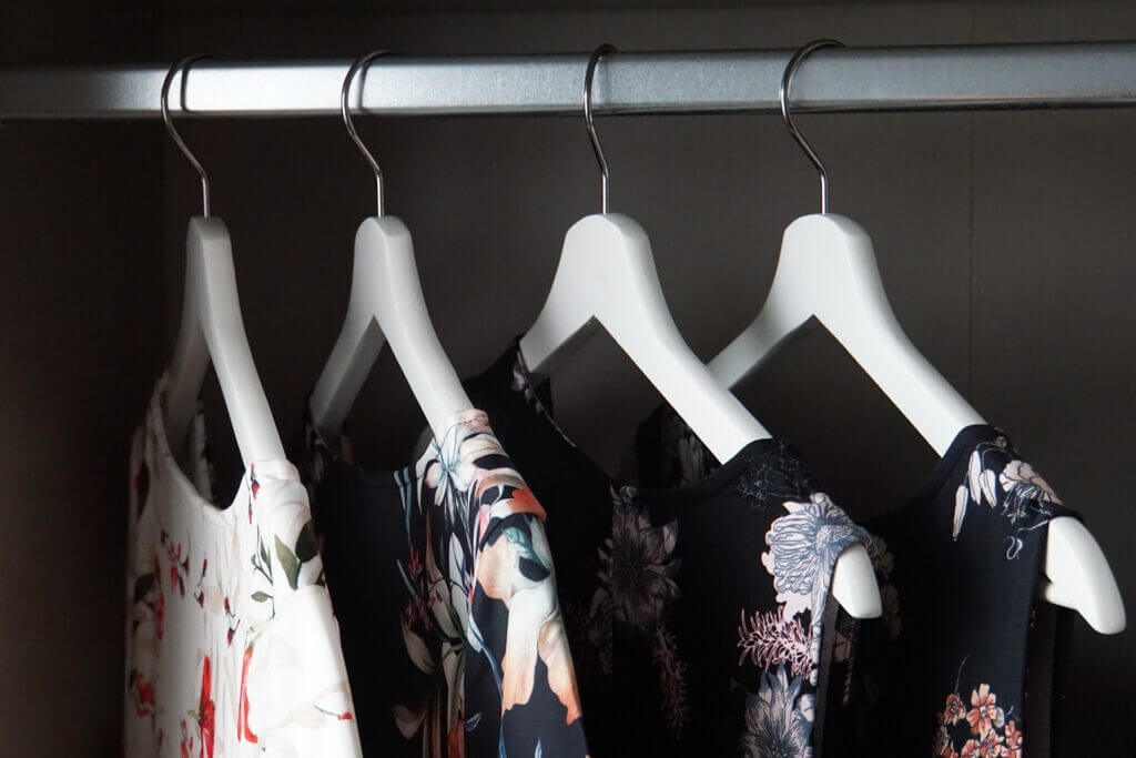 Vier Kleider auf Bügeln, als Sinnbild für die Capsule Wardrobe.